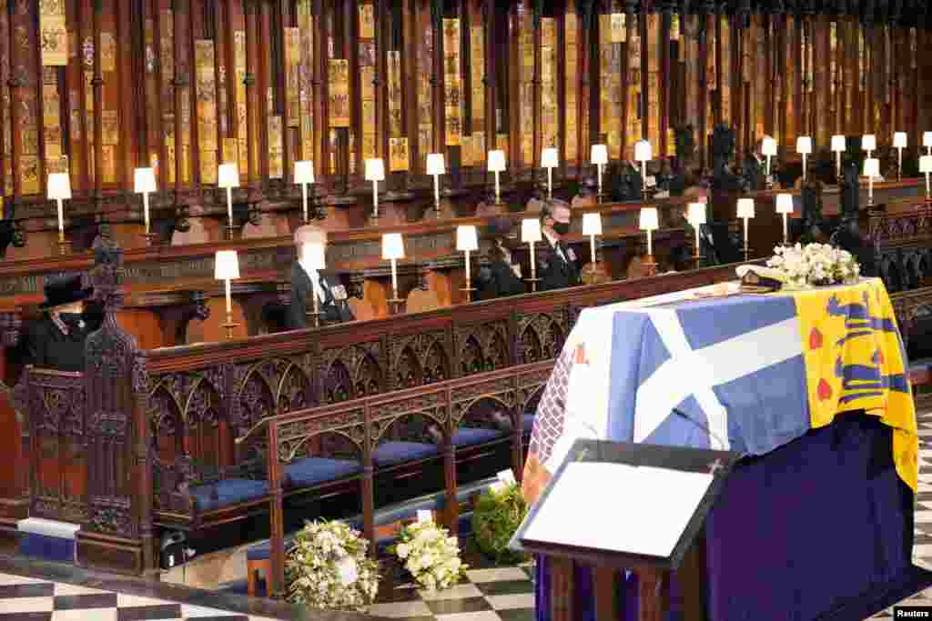 Queen Elizabeth II looks at the coffin of her husband, Britain&#39;s Prince Philip, who died at the age of 99, during his funeral service at St George&#39;s Chapel, in Windsor, April 17, 2021.