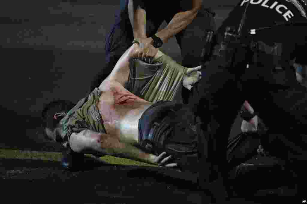 An injured demonstrator is dragged by police for detainment during a protest of plans by Netanyahu's government to overhaul the judicial system, in Tel Aviv, July 24, 2023.