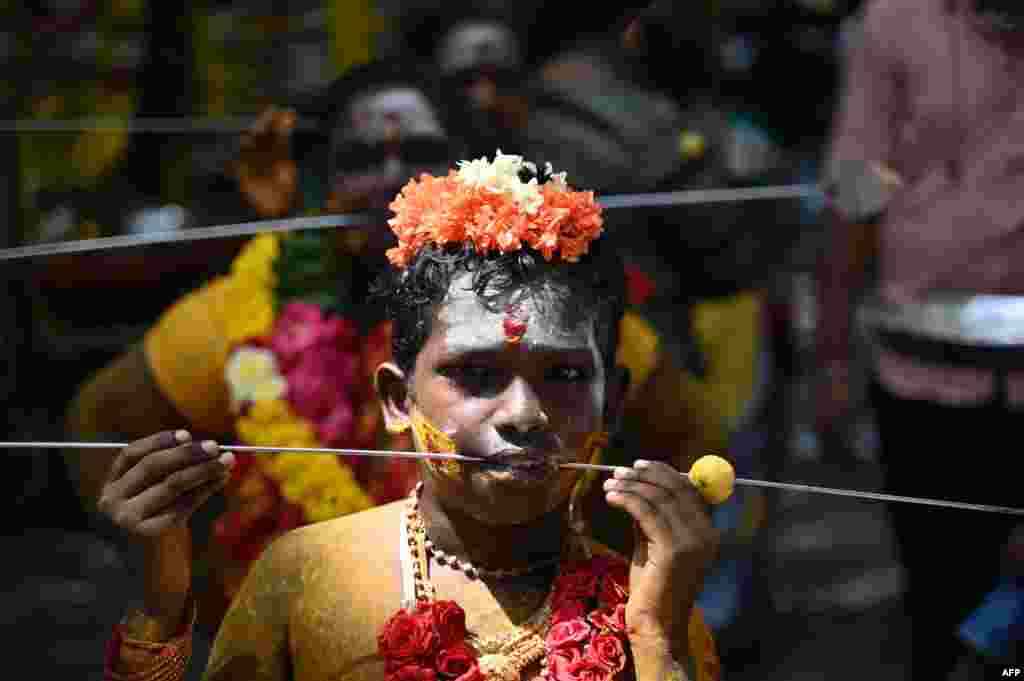 Devotees pierced their cheeks with a metal rod take part in a religious procession to celebrate Aadi festival in Chennai, India.
