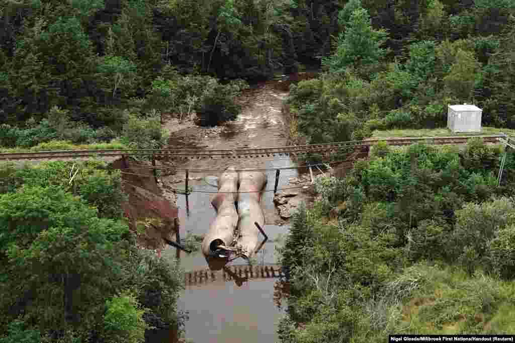 Water flows through a washed-out culvert on the main CN Rail line which leads to the port of Halifax, after the heaviest rain hit the Atlantic Canadian province of Nova Scotia in more than 50 years triggered floods, in Truro, Nova Scotia, Canada.