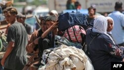 Palestinos viajan en un carro tirado por animales en una zona que alberga a personas desplazadas en Rafah, en el sur de la Franja de Gaza, el 19 de junio de 2024, en medio del conflicto en curso en el territorio palestino entre Israel y Hamás.