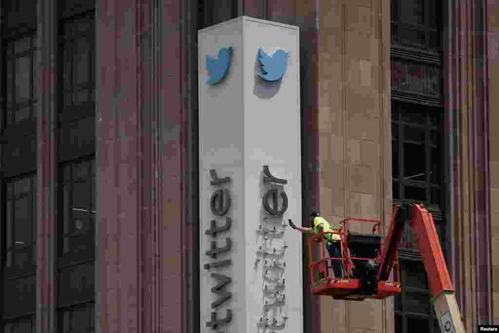 A worker dismantles a Twitter sign at Twitter's corporate headquarters, after Elon Musk renamed Twitter as X and unveiled a new logo, in downtown San Francisco, California, July 24, 2023.