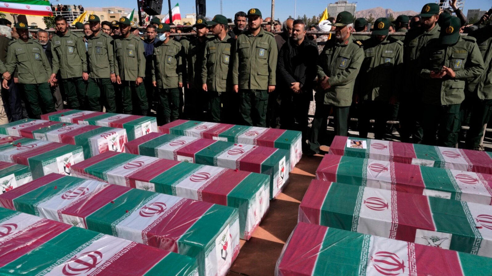 FILE - Revolutionary Guard members stand over the flag-draped coffins of victims a bomb explosion during their funeral ceremony in the city of Kerman, Iran, Jan. 5, 2024. The Iranian government linked the attack to ethnic-Tajik fighters of the Islamic State Khorasan Province.