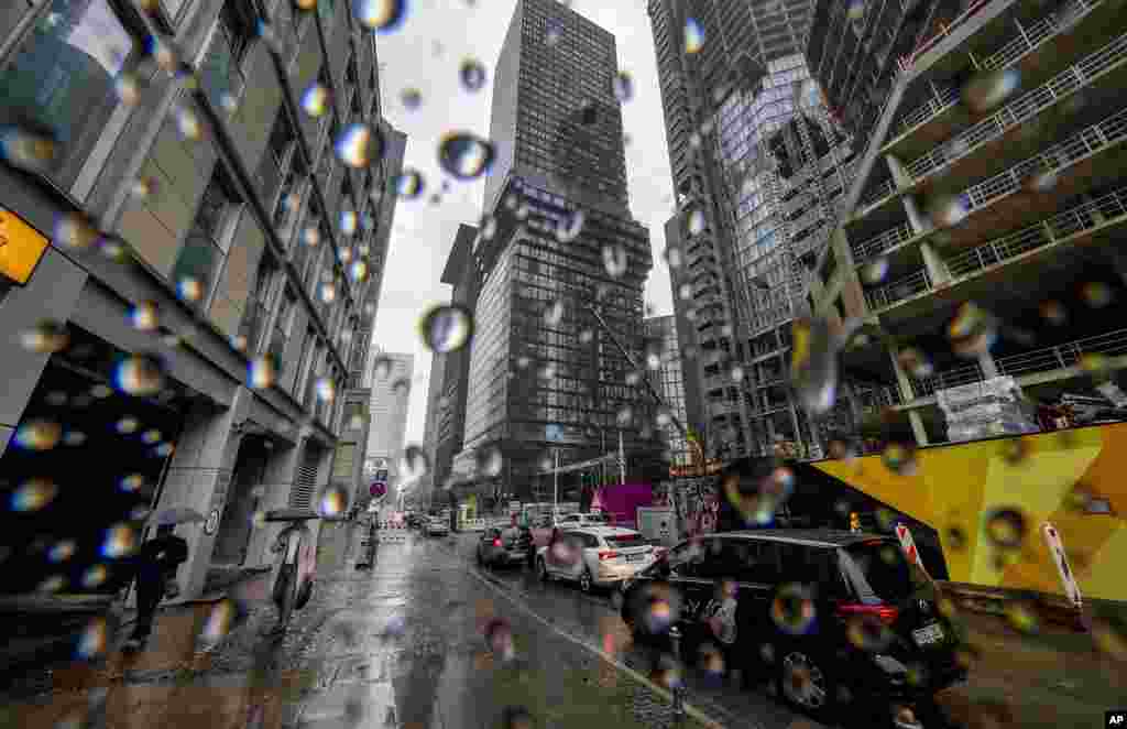 People walk through the banking district on a rainy Friday in Frankfurt, Germany.