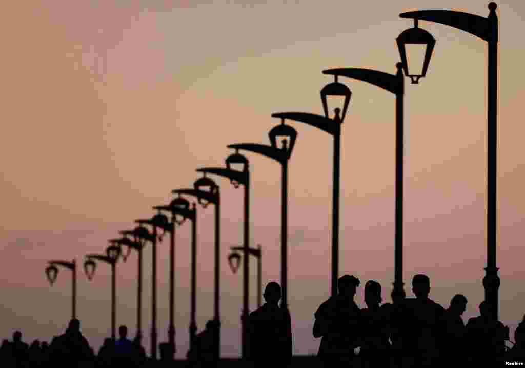 People walk at Beirut's seaside corniche during sunset, Lebanon.