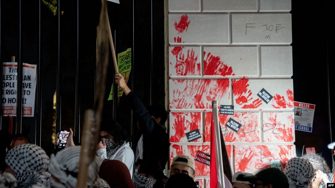 Grupa demonstranata je umočila ruke u crvenu farbu koja simbolizuje krv i ostavila otiske na ogradi oko bele kuće (Foto: Stefani Reynolds / AFP)