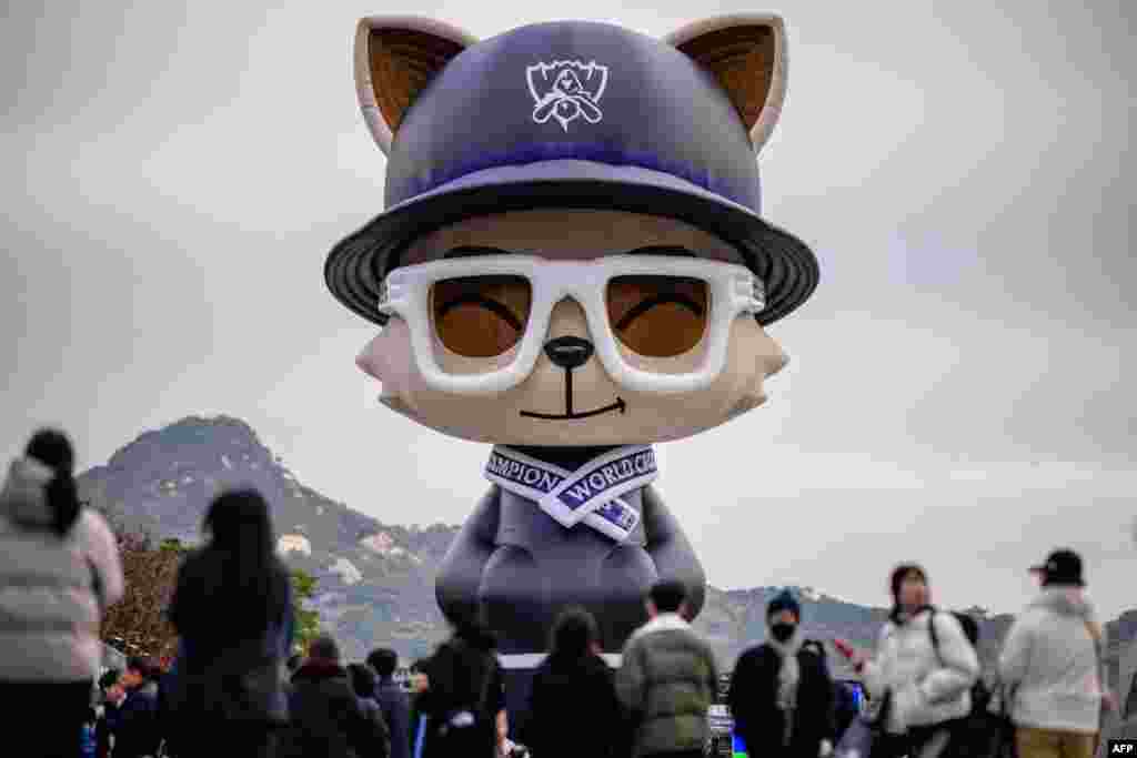 People walk in front of a huge temporarily installed Teemo at the 2023 Worlds Fan Fest for the League of Legends World Championship 2023, at Gwanghwamun Square in Seoul.