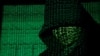 FILE - Binary code is projected onto a hooded man in this illustration photo taken on May 13, 2017. U.S. officials say that terror groups like IS and al-Qaida have reinvented themselves in recent years, posing new threats. (TPX Images via Reuters) 