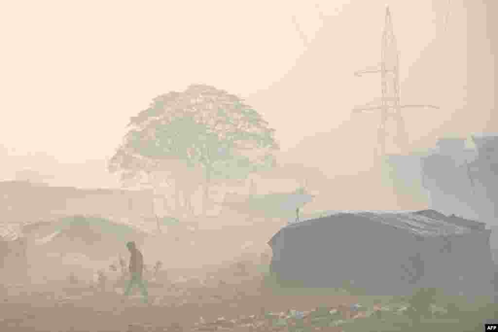A man walks past litter amid dense smog in the outskirts of Amritsar, India.