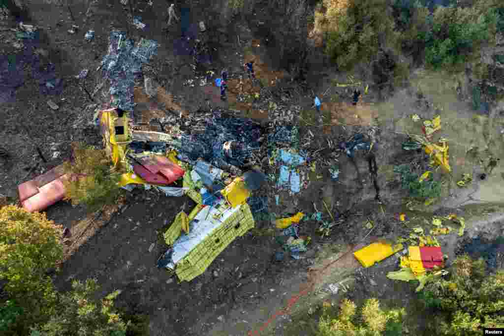 Rescuers operate at the site where a firefighting plane crashed after a water drop as a wildfire burns in Karystos on the island of Evia, Greece.