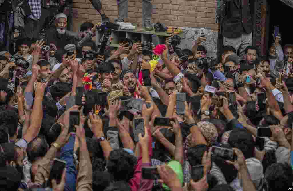 Supporters assemble to welcome top Kashmiri separatist leader Mirwaiz Umar Farooq, center, as he arrives to offer Friday prayers outside the Jamia Masjid, or Grand Mosque, in Srinagar, Indian-controlled Kashmir. Indian authorities released the key Muslim cleric after four years of house arrest and allowed him to lead Friday prayers in Srinagar, according to mosque authorities. 