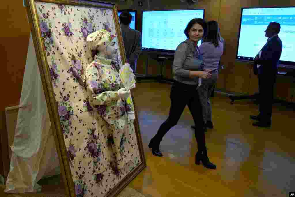 A visitor looks at a woman dressed up as part of an interactive art installation to spread awareness about communication during the Arab Forum for Sustainable Development at the U.N. headquarters in Beirut, Lebanon.