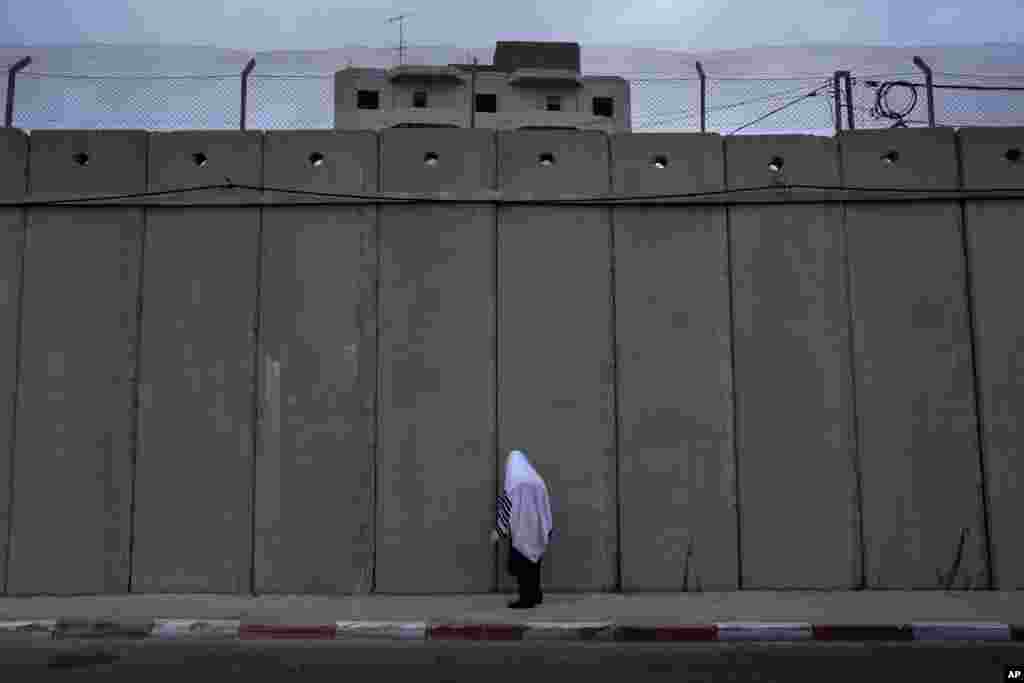 An ultra-Orthodox Jewish man prays at the concrete separation barrier built by Israel to secure Rachel's Tomb, Judaism's third holiest shrine, in the West Bank town of Bethlehem during the Jewish holiday of Sukkot.