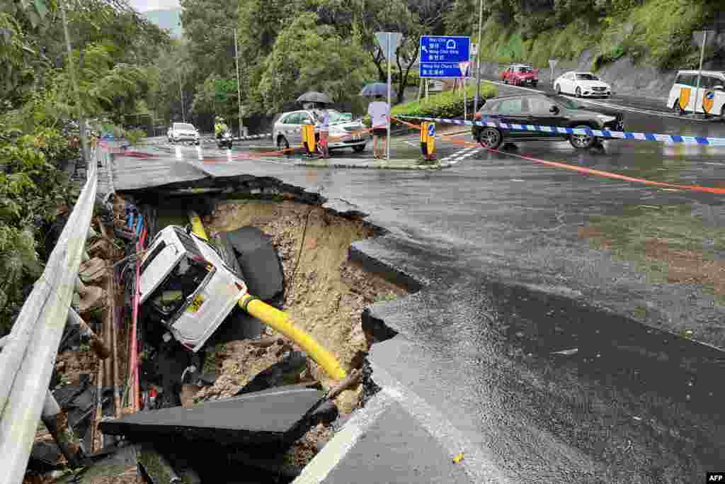 A vehicle is seen in a collapsed section of road in Hong Kong following record rainfall.
