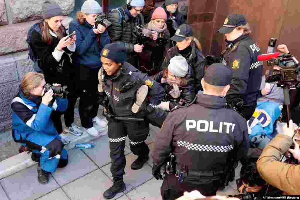 Norweigean police carry away Greta Thunberg as activists demonstrate outside the Ministry of Finance entrance and several other ministries in Oslo, Norway, in protest that the wind turbines at Fosen, which the Supreme Court has said are illegal, have not been demolished.