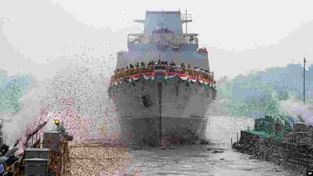 Confetti and smoke in the colors of the Indian national flag mark the entry of INS Vindhyagiri, a new warship for the Indian navy, into the Hooghly river in Kolkata, India, Aug. 17, 2023.