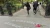 Sejumlah warga berjalan melewati grafiti yang dibuat untuk menarik perhatian terkait kasus kematian Jordan Neely di Washington Square Park, pada 5 Mei 2023. (Foto: AP/Brooke Lansdale)