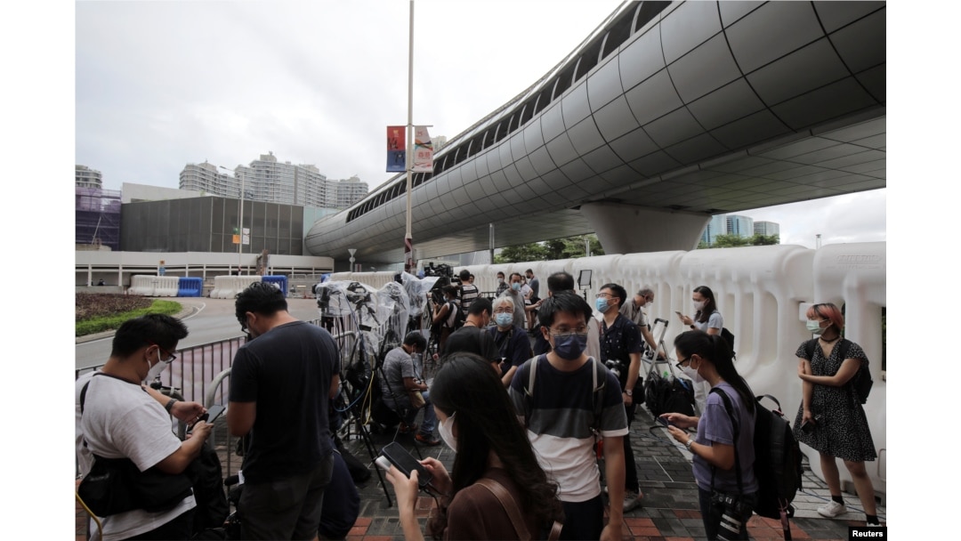 FILE - Journalists wait at a media position outside the Hong Kong West Kowloon railway station, in Hong Kong, China, June 30, 2022.