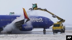 Petugas tengah membersihkan pesawat milik maskapai penerbangan Southwest Airlines sebelum lepas landas dari Bandara Internasional Salt Lake City Rabu, 22 Februari 2023. (AP/Rick Bowmer)