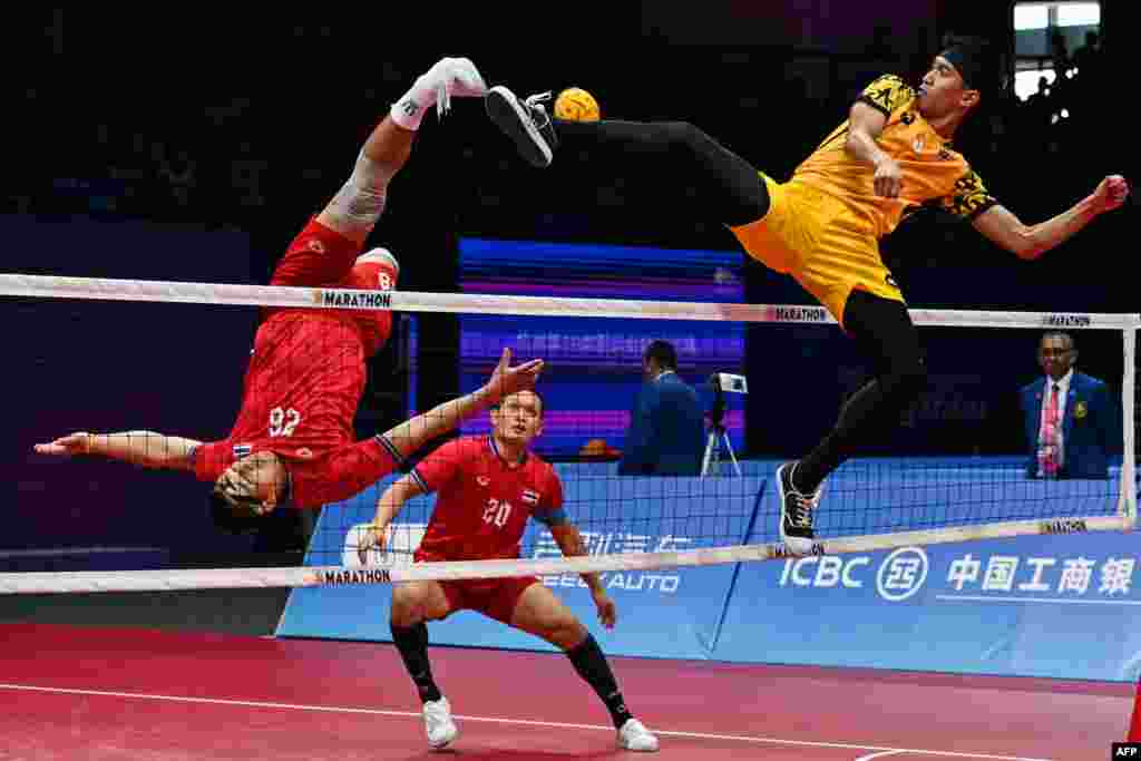Thailand's Pichet Pansan, left, kicks the ball as Malaysia's Muhammad Noraizat Mohd Nordin defends in the final match of the men's team sepak takraw during the Hangzhou 2022 Asian Games, in Jinhua, in China's eastern Zhejiang province.