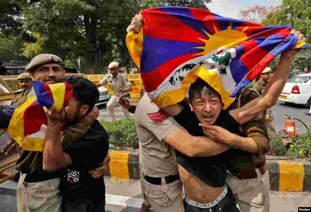 Tibetan exiles are detained by police during a protest against the visit of Chinese Foreign Minister Qin Gang who is scheduled to participate in G-20 foreign ministers' meeting, near the Chinese embassy in New Delhi, India.