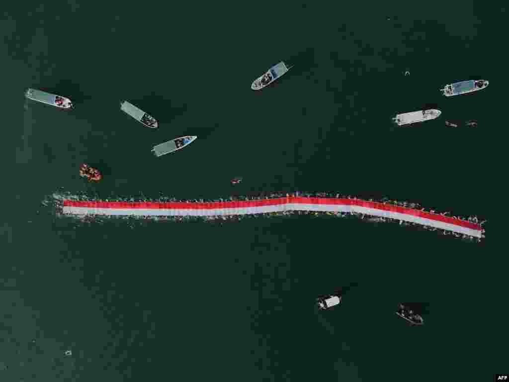 An aerial photo shows 145 swimmers taking part in an effort to stretch a 78-meter-long national flag in the sea ahead of Indonesia's 78th Independence Day in Makassar, South Sulawesi, Aug. 12, 2023.