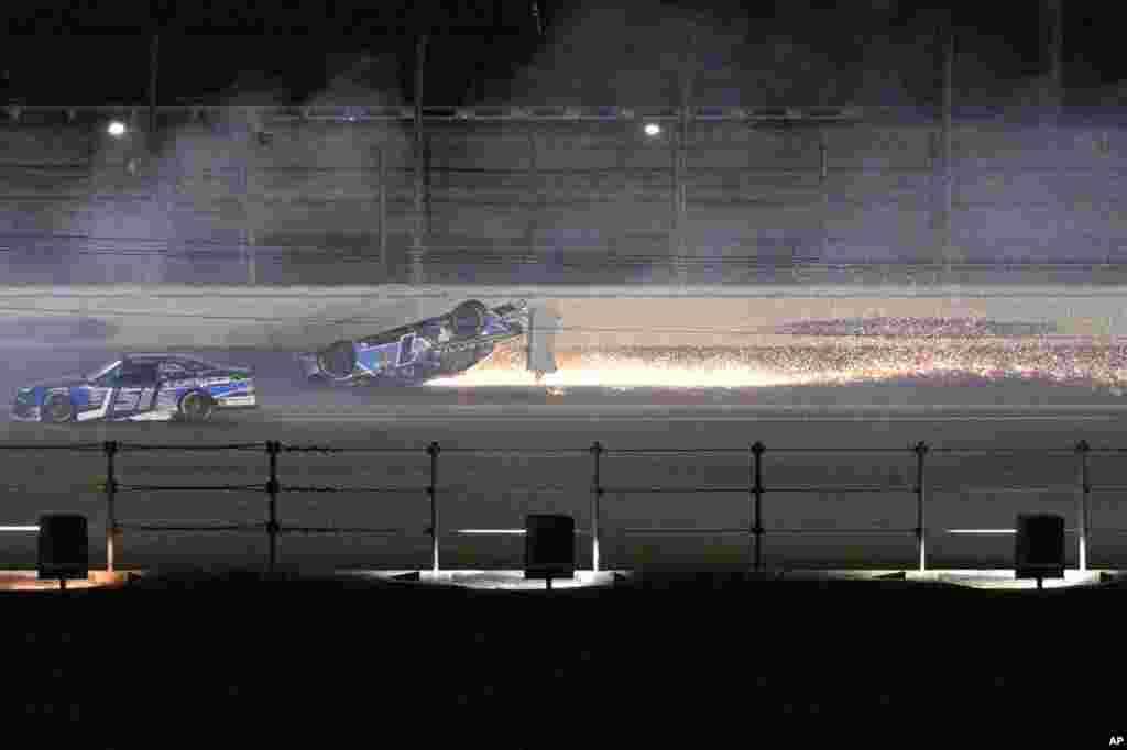 Sam Mayer's car slides on its roof along the back stretch after a collision on the final lap of the NASCAR Xfinity Series auto race at Daytona International Speedway, Feb. 18, 2023, in Daytona Beach, Florida.