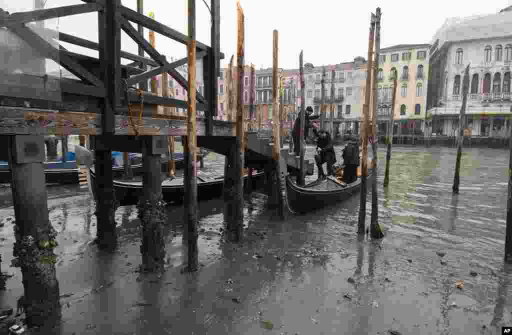 Passengers get off a gondola docked along a canal during a low tide in Venice, Italy. Some of Venice's secondary canals have practically dried up lately due a prolonged spell of low tides linked to a lingering high-pressure weather system.