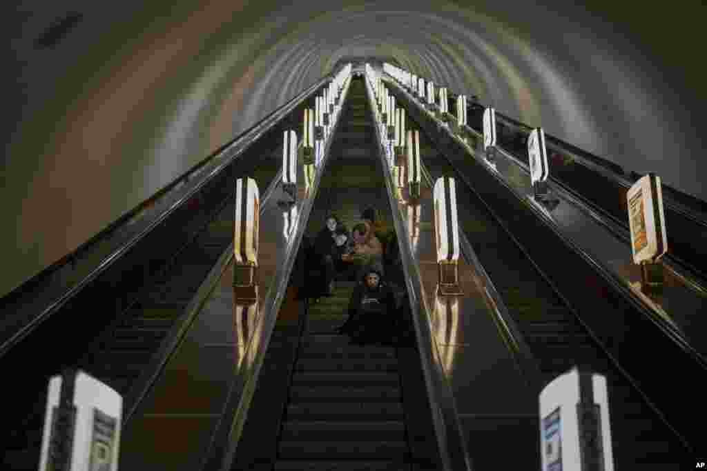 People take a shelter in a subway station being used as a bomb shelter during an air siren in Kyiv, Ukraine.