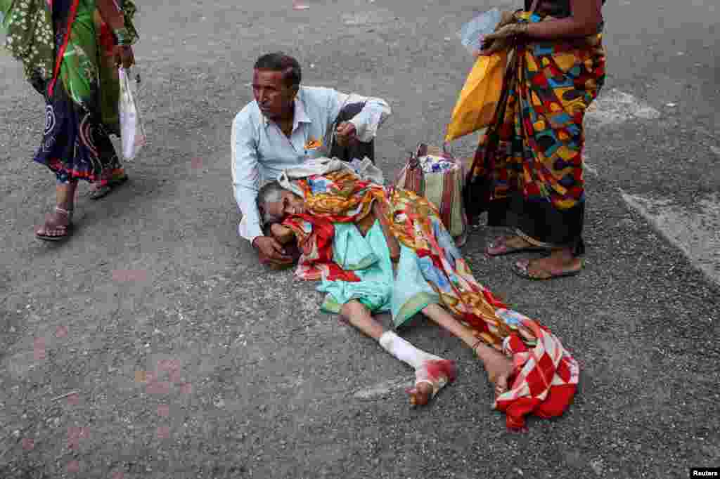 A man holds his mother Sayyanbai Ikkurwar as they wait for a stretcher at the Shankarrao Chavan Government Medical College and Hospital in Nanded, India.