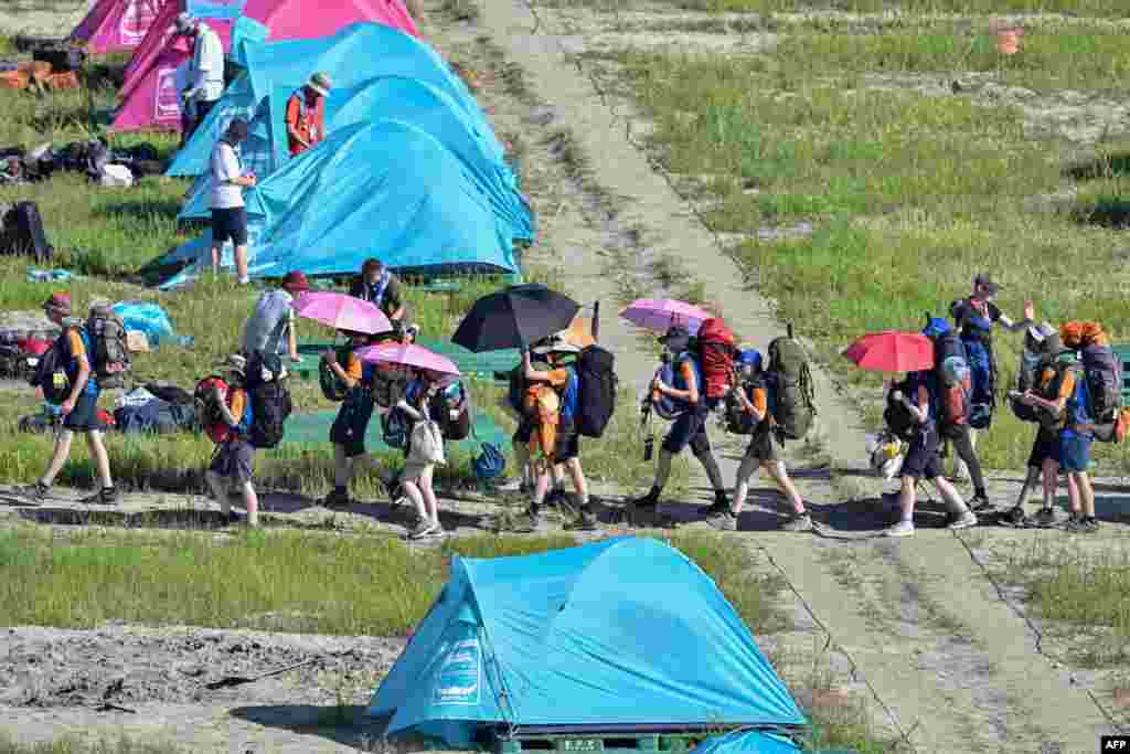 Scouts leave the campsite of the World Scout Jamboree in Buan, North Jeolla province, South Korea. Organizers of the World Scout Jamboree asked host South Korea to "urgently" evacuate tens of thousands of children from their campsite ahead of a typhoon, just days after a heatwave caused mass scout illnesses.