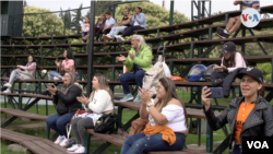 Los familiares de los jugadores de sóftbol aprovechan la oportunidad para hacer amigos y alentar desde la grada a sus parientes. Foto: Israel Navas, VOA.