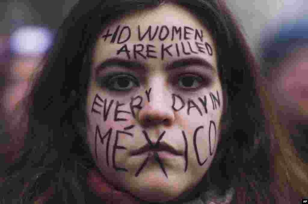 A woman from Mexico with a message draw in her face about the situation in her home country, attends a rally marking International Women's Day 2023 in Berlin, Germany.