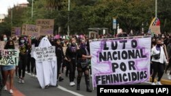ARCHIVO - Activistas marchan con una pancarta durante el Día Internacional de la Mujer en Bogotá, Colombia, el 8 de marzo de 2021.