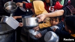 Arhiva - Palestinska deca čekaju da prime obrok koji su pripremile humanitarne kuhinje usred nestašice hrane u Rafi, na ugu Pojasa Gaze, 5. marta 2024.