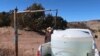 FILE - Phillip Yazzie waits for a water drum in the back of his pickup truck to be filled in Teesto, Arizona, on the Navajo Nation, Feb. 11, 2021. 