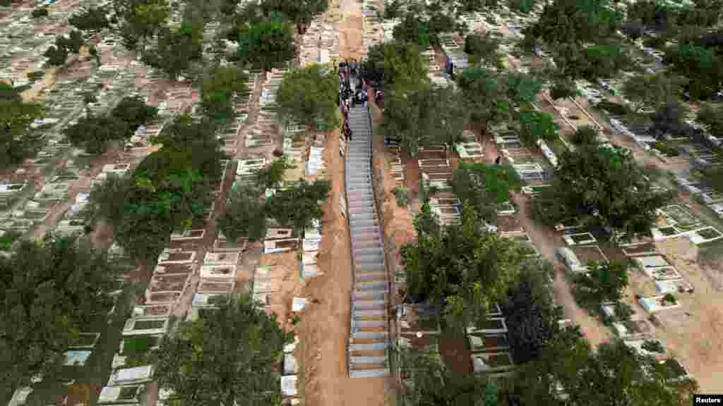 Mourners bury the bodies of Palestinians from Zraiee family, who were killed in Israeli strikes, at a cemetery in the central Gaza Strip.