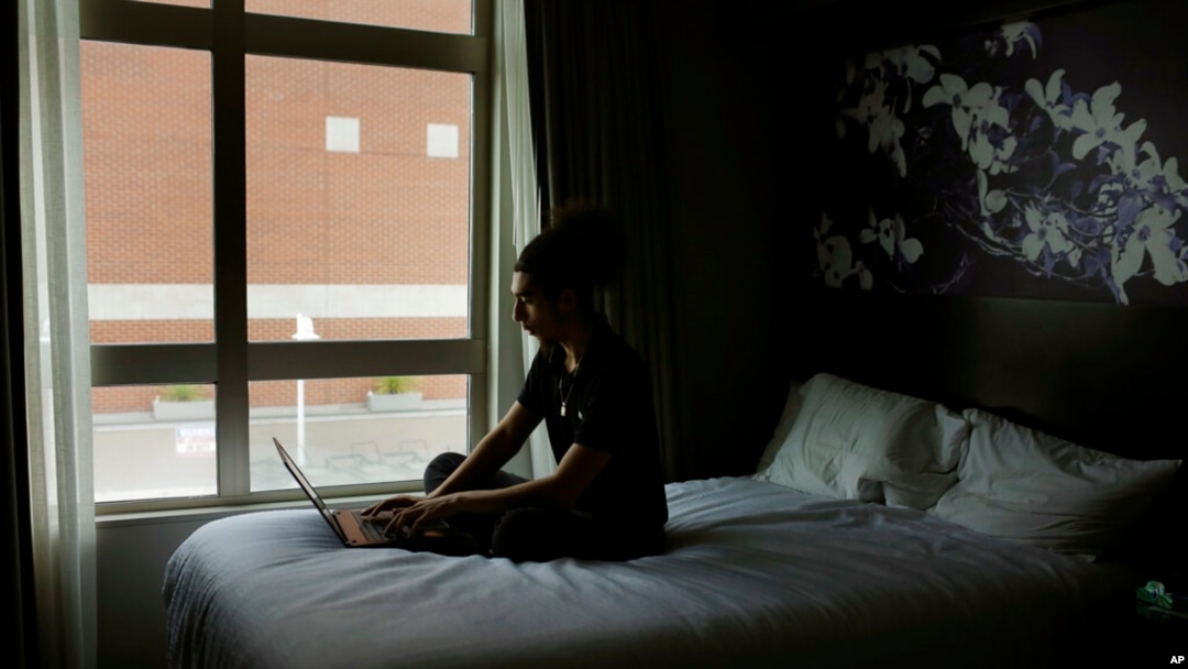 In this May 5, 2020, photo, Morehouse College freshman Joseph Ramirez works on his computer in Atlanta.