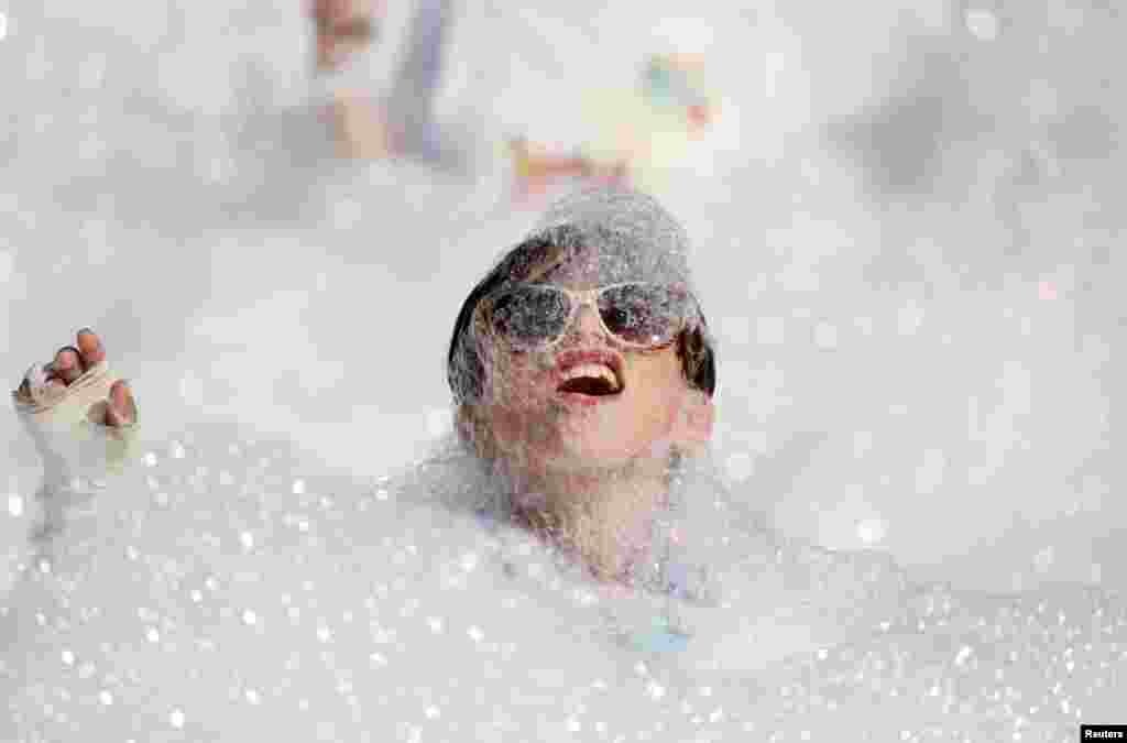 A participant runs through a foam bath during the 'Colour My Run' charity fun run in Ta' Xbiex, Malta.