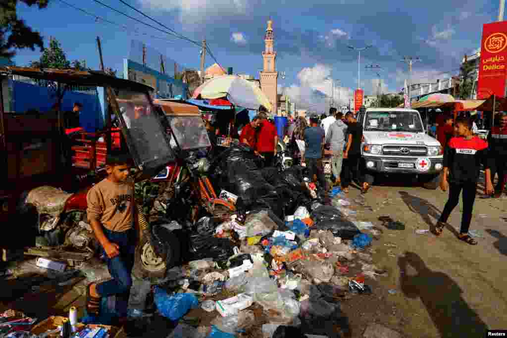 Palestinians walk past piles of garbage that threaten to spark an environmental catastrophe, amid the ongoing Israeli-Palestinian conflict, in Khan Younis in the southern Gaza Strip.