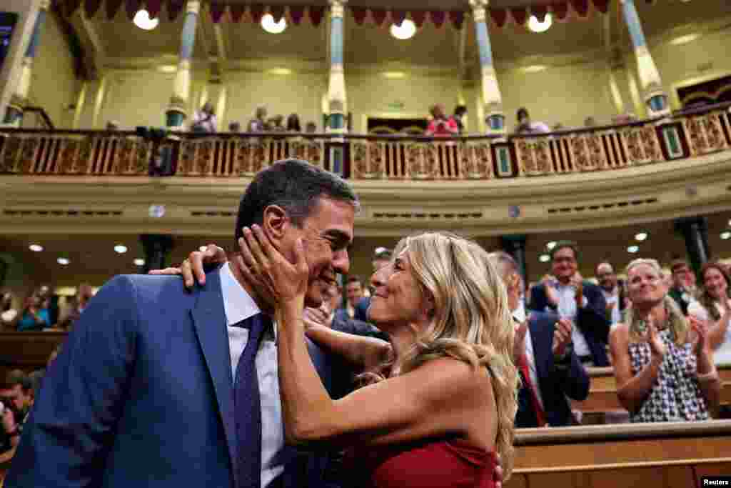 Spain's left-wing Sumar leader Yolanda Diaz (R) greets acting Prime Minister and Socialist Party leader Pedro Sanchez at the parliament, in Madrid.