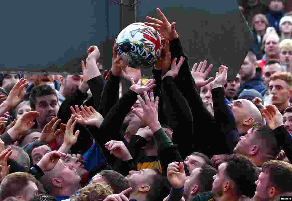 Players fight for the ball during the annual Shrovetide football match in Ashbourne, Britain.