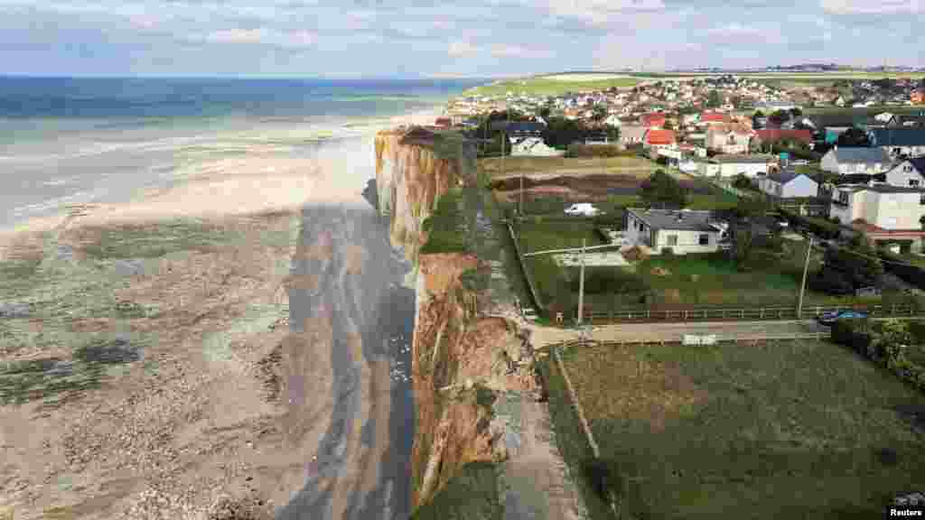 A view shows a road and houses near a part of cliff that crashed into the sea due to coastal erosion in Criel-sur-Mer, France.