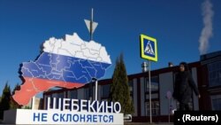  A woman walks past an installation with the slogan “Shebekino does not bow down,” in Shebekino, Russia, March 11, 2024.