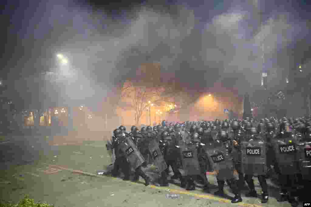 Police in riot gear face protesters in Tbilisi, Georgia, March 8, 2023. Police fired water cannon and tear gas to disperse thousands of protesters who rallied against a planned "foreign agent" law reminiscent of Russian legislation used to silence critics.