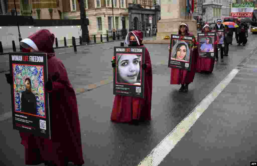 Demonstrators hold placards reading ""Women, Life, Freedom" on Whitehall in central London as they demonstrate against the persecution of women in Iran.