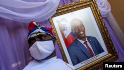 Un hombre aparece junto a un retrato del asesinado presidente haitiano, Jovenel Moïse, colocado en un monumento en el ayuntamiento de Cabo Haitiano, Haití, el 22 de julio de 2021. [REUTERS]