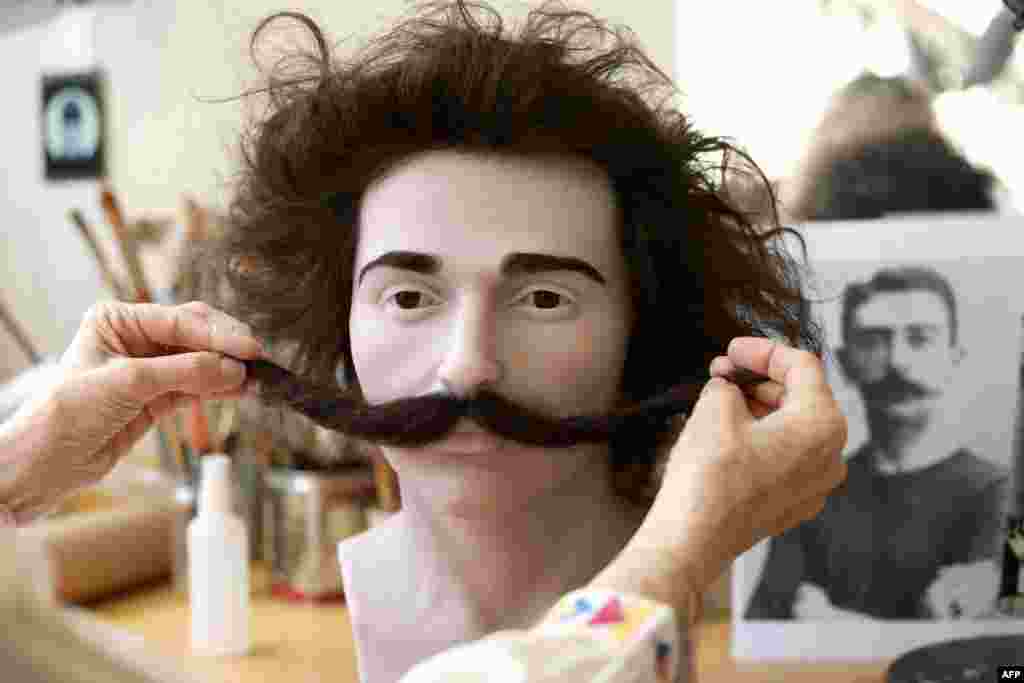 A employee of the Grevin wax museum works on the wax figure of Pierre de Coubertin, co-founder of the International Olympic Committee, at the museum's workshop in Paris.