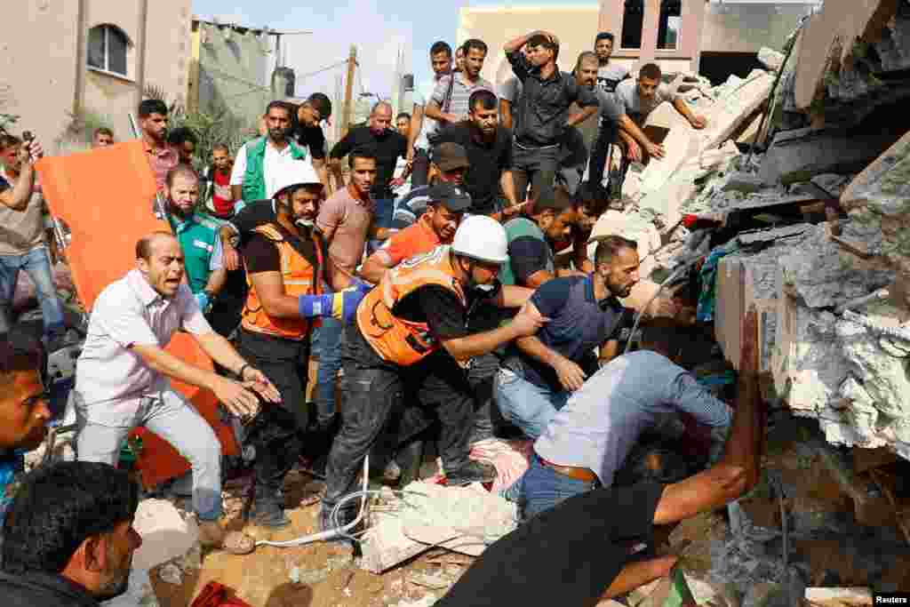 Palestinians search for people under the rubble of a house destroyed in Israeli strikes in Khan Younis, in the southern Gaza Strip. Israel battered Gaza after suffering its bloodiest attack in decades, when Hamas fighters rampaged through Israeli towns killing 600 and abducting dozens more.