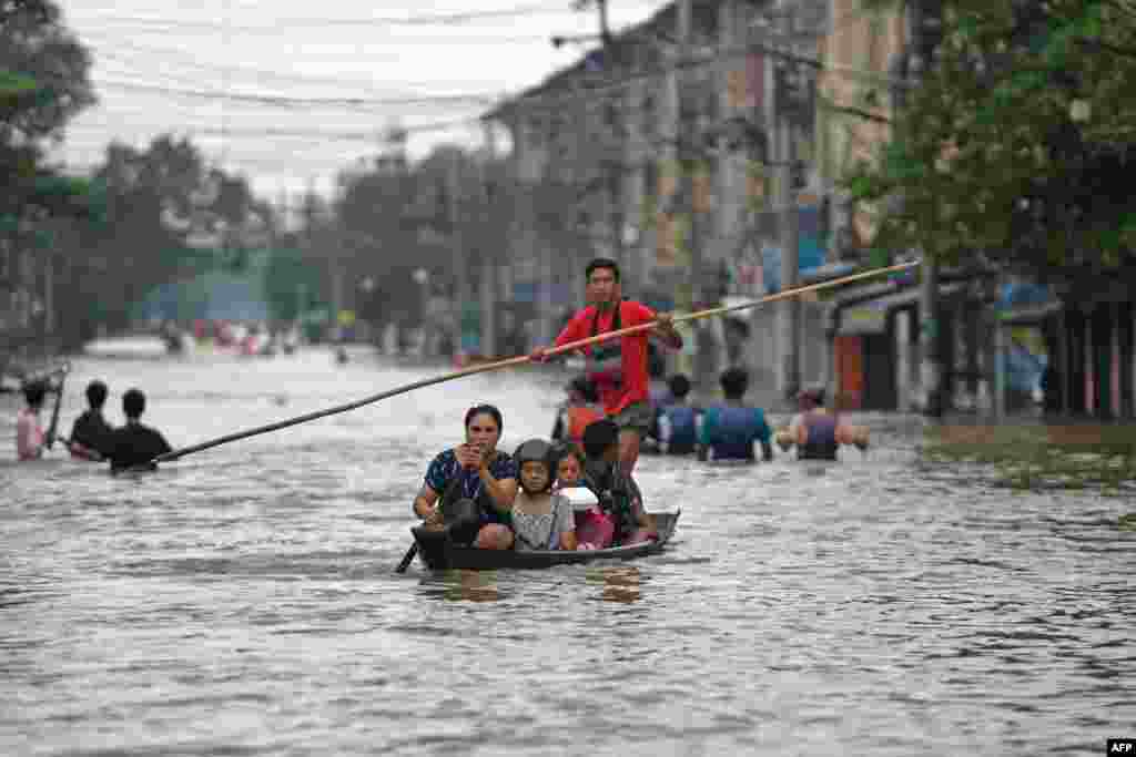 Local residents make their way through a flooded street after heavy rains in Myanmar's Bago region.